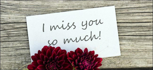 "Bardzo za tobą tęsknię" napisane na tabliczce obok kwiatów