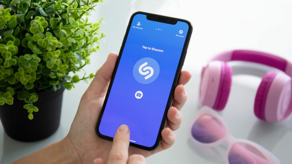 Person identifying a song using the Shazam app on an iPhone