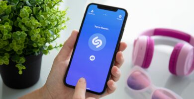 Person identifying a song using the Shazam app on an iPhone
